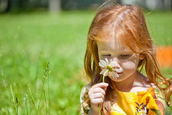 Uma menina ruiva com uma flor — Fotografia de Stock