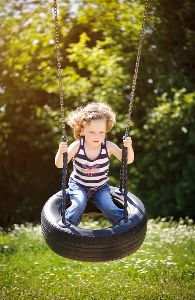 Little girl is swinging — Stock Photo, Image