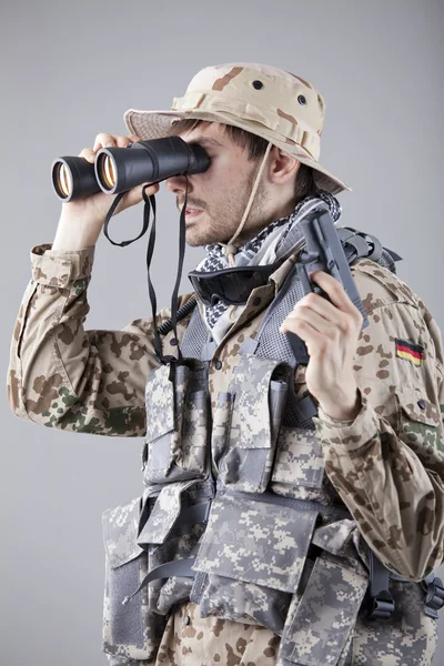 Soldado mirando a través de prismáticos — Foto de Stock