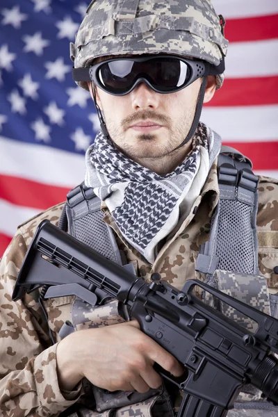 Soldat mit Waffe über amerikanischer Flagge — Stockfoto