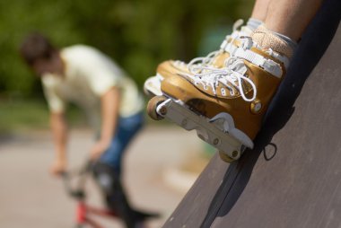 In-line skater in outdoor skatepark clipart