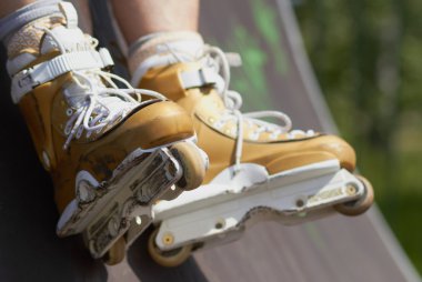 In-line skater in outdoor skatepark clipart