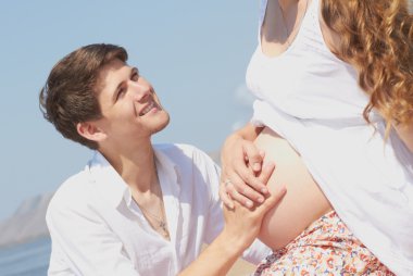 Happy young husband and his pregnant wife clipart