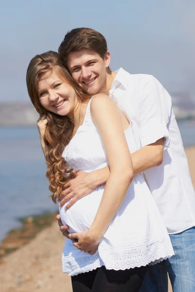 Chica embarazada feliz y su marido cariñoso — Foto de Stock