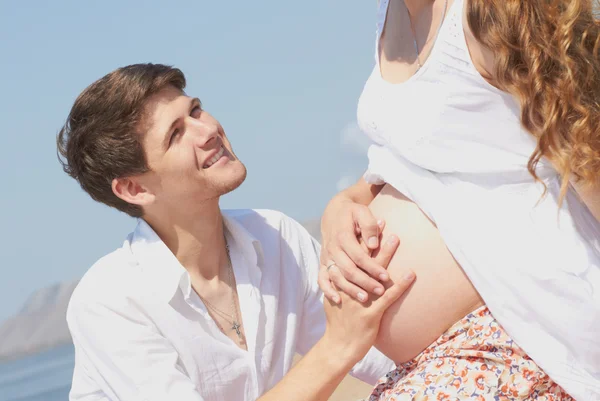 Счастливый молодой муж и его беременная жена — стоковое фото