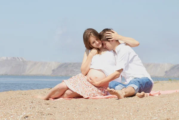 Felice giovane famiglia incinta in mare — Foto Stock