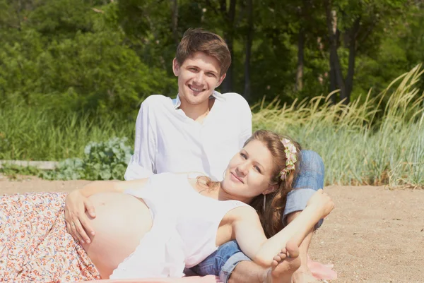 Счастливая беременная девушка и ее любящий муж — стоковое фото