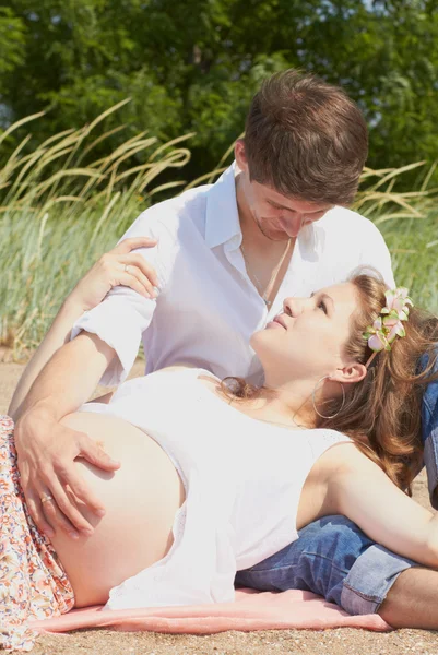 Chica embarazada feliz y su marido cariñoso —  Fotos de Stock