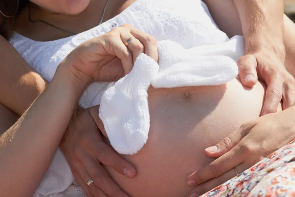 Gravid ung familj håller lite strumpor — Stockfoto