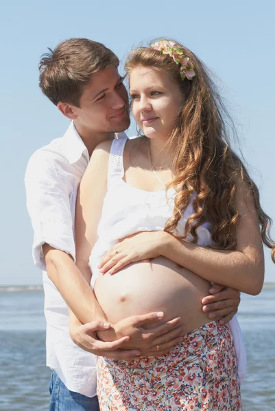 Chica embarazada feliz y su marido cariñoso —  Fotos de Stock