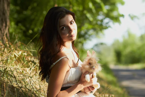 Belle jeune fille tenant un lapin — Photo
