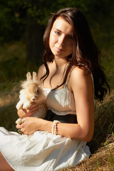 Beautiful young girl holding a bunny — Stock Photo, Image