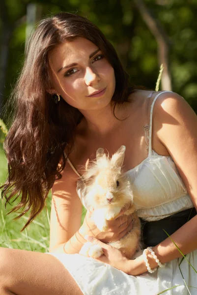 Beautiful young girl holding a bunny — Stock Photo, Image