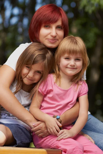 Söta små flickor med deras mamma utomhus — Stockfoto