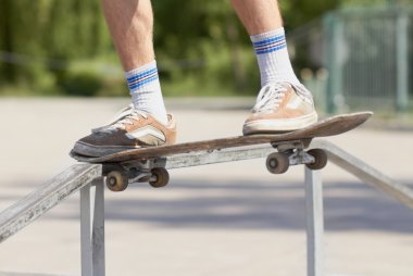 Skater doing noseslide on fun-box in skatepark clipart