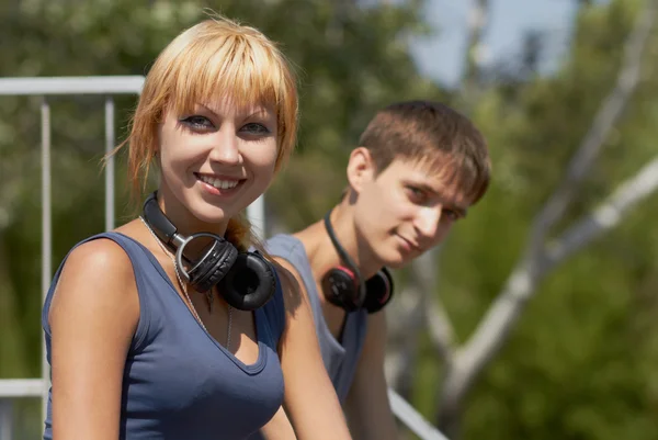 Jovens adolescentes positivos com fones de ouvido — Fotografia de Stock