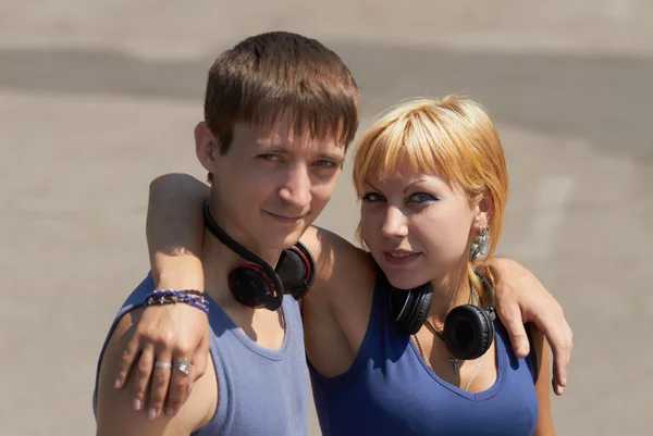 Młoda para z słuchawki pozowanie — Zdjęcie stockowe