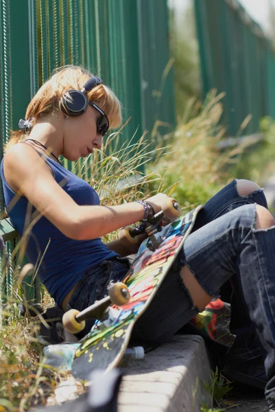 Молодий панк-дівчина ковзаняр в навушниках — стокове фото
