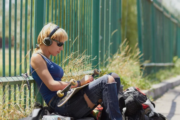 Young punk girl skater in headphones — Stok fotoğraf