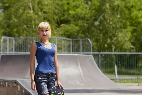 Punk girl patineuse avec planche à roulettes dans skatepark — Photo