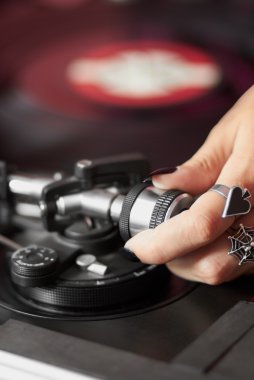 Female DJ adjusting turntable tonearm