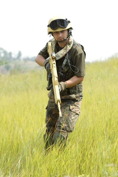 Молодой солдат в шлеме с пистолетом — стоковое фото