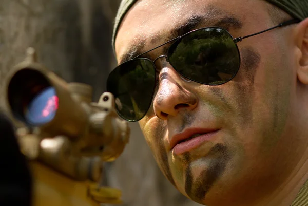 Soldaat in zonnebril richt met een pistool — Stockfoto