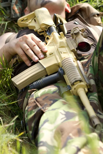 Soldado descansa segurando um rifle — Fotografia de Stock