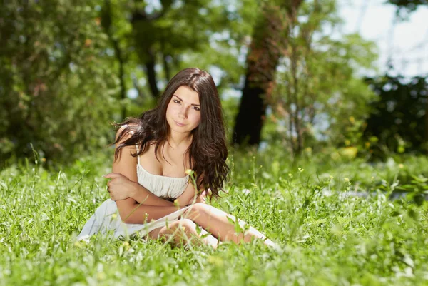Молода дівчина охолоджує в зеленому парку на відкритому повітрі — стокове фото