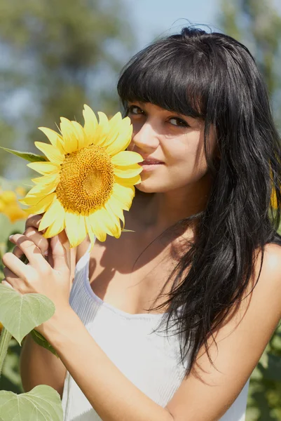 Jong meisje met zonnebloem buitenshuis — Stockfoto