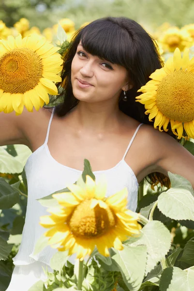 Jong meisje met zonnebloemen in veld — Stockfoto