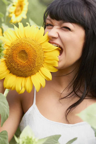 Grappig meisje bijten een zonnebloem — Stockfoto