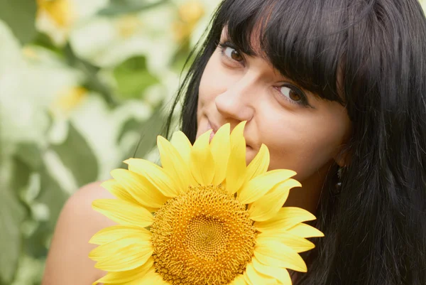 Young girl with sunflowers in field — Stock Photo, Image