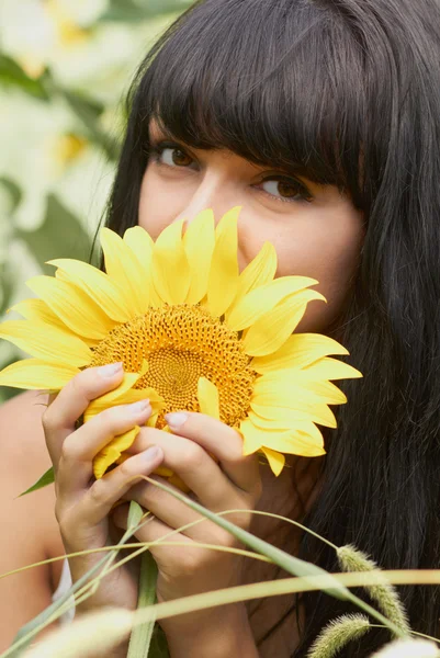 Jong meisje met zonnebloem buitenshuis — Stockfoto