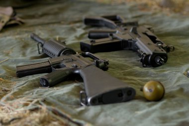 Arsenal of guns lying on the ground clipart