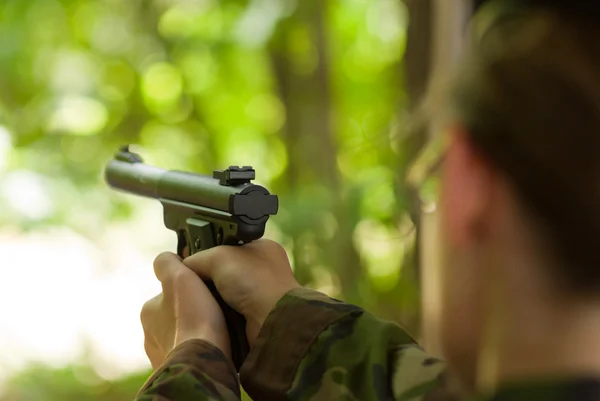 Soldado fêmea atirando com uma pistola — Fotografia de Stock