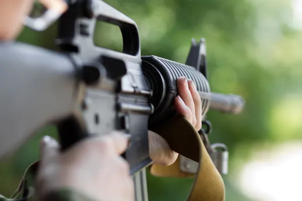 Soldado fêmea atirando com uma arma — Fotografia de Stock