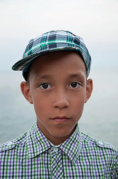 Trauriger Junge mit braunen Augen in Mütze lizenzfreie Stockbilder