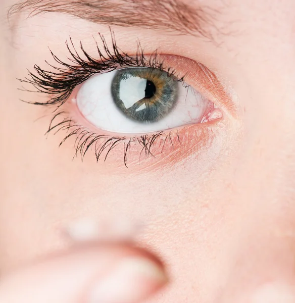 Закрытие вставки контактной линзы в женский глаз — стоковое фото