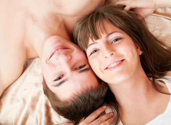 Jonge gelukkige paar in bed — Stockfoto
