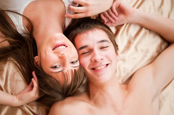 Jovem casal feliz na cama — Fotografia de Stock