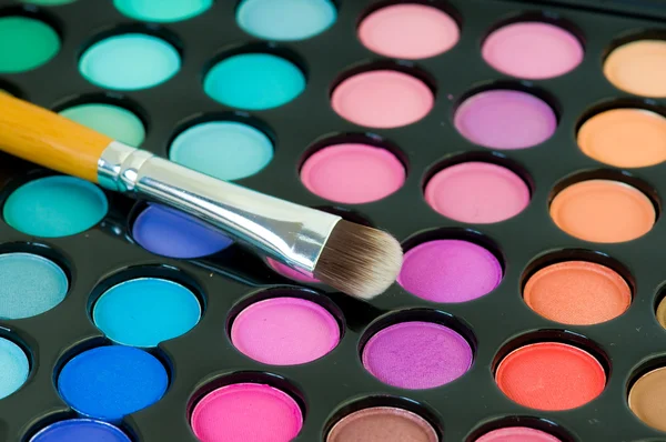 Sombras de olhos multicoloridas com escova de cosméticos Fotografias De Stock Royalty-Free