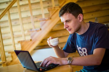 Man sitting at home and using laptop computer. clipart