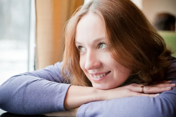Pretty young woman leaning on a table — Stock Photo, Image