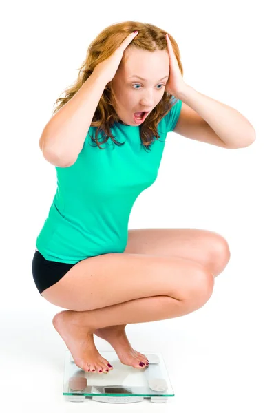 Uma jovem grita enquanto vê seu peso na balança — Fotografia de Stock