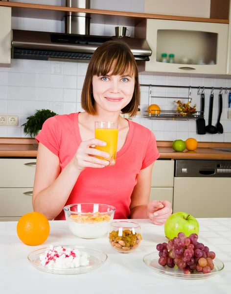 Jovem mulher bebendo suco de laranja em casa — Fotografia de Stock
