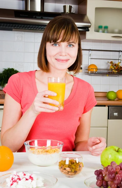 Mujer joven bebiendo jugo de naranja en casa — Foto de Stock