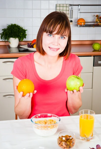 Hermosa mujer sosteniendo una manzana y naranja — Foto de Stock