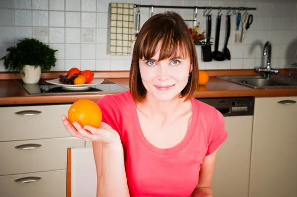 Hermosa mujer sosteniendo naranja — Foto de Stock