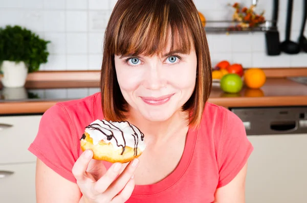 एक डोनट का आनंद लेने वाली युवा महिला — स्टॉक फ़ोटो, इमेज